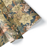 Rolled gift wrap featuring illustrated hellebore flowers, berries, and a deer on a dark teal background. Illustrated by Lisel Ashlock.