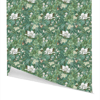 Magnolia floral gift wrap featuring white flowers, green leaves, and small birds on a teal background. Illustrated by Lisel Ashlock.