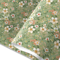 Rolled gift wrap featuring white anemones and coral flowers on a sage green background. Illustrated by Lisel Ashlock.