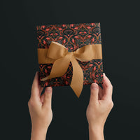 Hands holding a square gift wrapped in bright mahogany damask patterned paper with a gold ribbon bow against dark background. Illustrated by Lisel Ashlock.