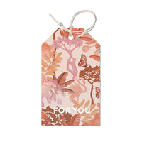 A decorative gift tag featuring botanical illustrations in coral and pink tones with butterflies and "FOR YOU" text. Illustrated by Lisel Ashlock.
