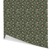 A roll of gift wrap featuring a botanical pattern of lily flowers and ferns in teal and cream on a spruce green background. Illustrated by Lisel Ashlock.