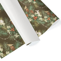 Rolls of Holly & Hare gift wrap in moss green featuring evergreen branches, berries, pinecones, and rabbits. Illustrated by Lisel Ashlock.