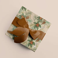 A wrapped gift with botanical holly and hare patterned paper tied with a bronze textured ribbon bow. Illustrated by Lisel Ashlock.