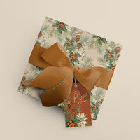 Rolled gift wrap in blush with holly, hare, and pinecone botanical pattern tied with golden ribbon and tag. Illustrated by Lisel Ashlock.