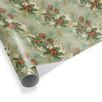 Rolled gift wrap featuring holly leaves, berries, pinecones, and white hares on sage green background. Illustrated by Lisel Ashlock.