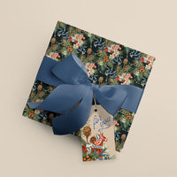 Wrapped gift with dark floral patterned paper, blue ribbon bow, and tag reading "for you" illustrated by Lisel Ashlock.