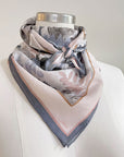 Angelite silk cotton scarf in soft pink and gray tones with botanical leaf design, draped on mannequin. Illustrated by Lisel Ashlock.