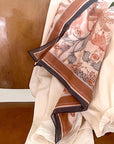 Silk cotton scarf in sunstone featuring botanical illustrations of flowers and ferns in rust and cream tones. Illustrated by Lisel Ashlock.