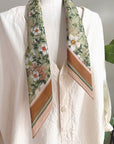 Silk cotton scarf in medium size with anemone Ceylon green floral pattern worn around neck of white linen shirt. Illustrated by Lisel Ashlock.