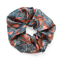 Silk scrunchie with ornate blue and red floral pattern featuring roses and botanical motifs. Illustrated by Lisel Ashlock.