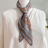 Cream linen shirt styled with apricot filigree patterned silk scarf tied at neck, illustrated by Lisel Ashlock.