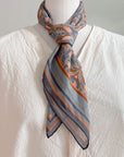 Cream linen shirt styled with apricot filigree patterned silk scarf tied at neck, illustrated by Lisel Ashlock.