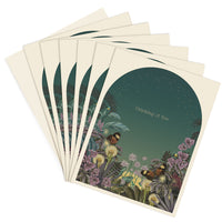 A fan of greeting cards with dark teal circular design featuring botanical illustrations and butterflies with "Thinking of You" text. Illustrated by Lisel Ashlock.