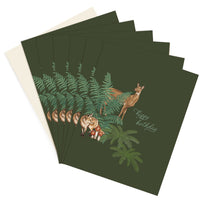 A stack of forest green birthday greeting cards featuring illustrated woodland animals among ferns. Illustrated by Lisel Ashlock.