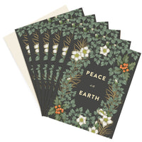 A stack of dark green greeting cards with white flowers and orange berries illustrated by Lisel Ashlock.