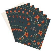 A stack of dark teal birthday greeting cards with orange floral design and "Happy Birthday" text. Illustrated by Lisel Ashlock.