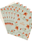 A fan of Happy Birthday greeting cards with orange flowers on sage green, illustrated by Lisel Ashlock.