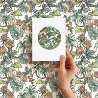 Hand holding blank greeting card with circular botanical design against repeated floral pattern. Illustrated by Lisel Ashlock.