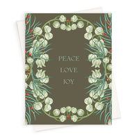 Holiday greeting card with olive background, white snowdrop flowers, teal evergreen sprigs, red berries, and centered text reading "Peace Love Joy." Illustrated by Lisel Ashlock.