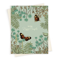 Greeting card with sage green background, botanical illustrations, and two butterflies, text reads "To the Happy Couple" Illustrated by Lisel Ashlock