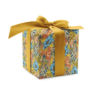 A decorative gift box wrapped in colorful floral garden party patterned paper tied with a golden ribbon bow. Illustrated by Lisel Ashlock.