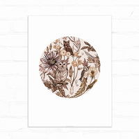 Circular botanical illustration featuring owls and birds among flowers and foliage in sepia tones. Illustrated by Lisel Ashlock.