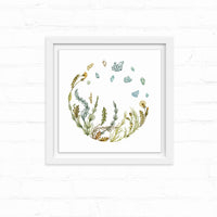 Watercolor illustration of herbs and wildflowers arranged in a circular wreath with blue crystals floating above, on white background. Illustrated by Lisel Ashlock.