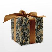 Nephrite gift wrap box with gold ribbon bow and botanical floral pattern in green and gold tones. Illustrated by Lisel Ashlock.