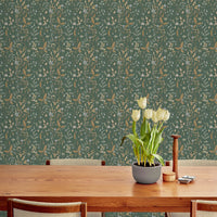 A wooden dining table with mid-century chairs displays white tulips against green botanical wallpaper. Illustrated by Lisel Ashlock.