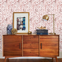 Mid-century wooden credenza against pink floral wallpaper with framed art and brass lamp. Illustrated by Lisel Ashlock.