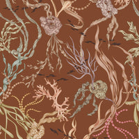 Atoll Wallpaper in sienna with coral, seaweed, pearls and swimming fish on warm brown background. Illustrated by Lisel Ashlock.