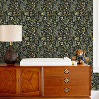 Secret Garden Wallpaper in ebony with botanical print behind mid-century wood dresser. Illustrated by Lisel Ashlock.