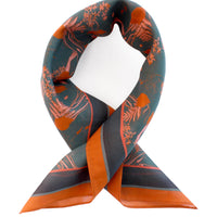 Viridian silk cotton scarf with orange botanical patterns and solid orange trim, looped and displayed against white background. Illustrated by Lisel Ashlock.