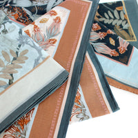 Silk cotton scarf with botanical floral patterns in coral, cream, and teal colors. Illustrated by Lisel Ashlock.