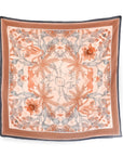 Square silk cotton scarf in sunstone with botanical and animal motifs in orange and gray. Illustrated by Lisel Ashlock.