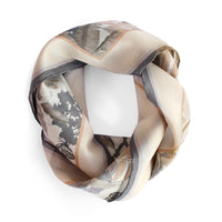 Beige and gray silk cotton scarf with world map and botanical illustrations, draped in a circle. Illustrated by Lisel Ashlock.