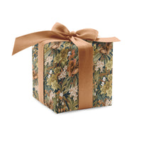 Wrapped gift box with dark floral hellebore pattern and tan ribbon bow. Illustrated by Lisel Ashlock.