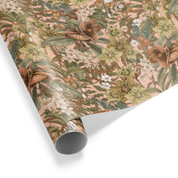 Rolled gift wrap featuring botanical illustration of hellebore roses, berries, and foliage on blush pink background. Illustrated by Lisel Ashlock.