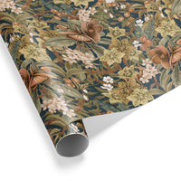 A roll of botanical gift wrap featuring brown flowers, white blooms, and sage green leaves on a dark teal background. Illustrated by Lisel Ashlock.