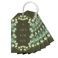 Multiple olive green gift tags with white snowbell flowers and green foliage, strung together with white cord. Illustrated by Lisel Ashlock.
