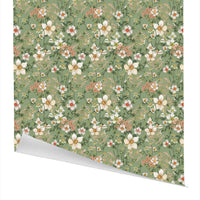 Rolled gift wrap featuring a dense floral pattern of white and coral anemones with green foliage on a sage green background. Illustrated by Lisel Ashlock.