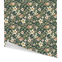 Rolled gift wrap with repeating floral pattern of white and coral anemones on dark green background. Illustrated by Lisel Ashlock.