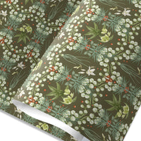 Rolled gift wrap featuring white snowbell flowers and red berries on olive green background, illustrated by Lisel Ashlock.