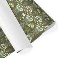 Rolls of green botanical gift wrap featuring white snowbell flowers, red berries, and foliage. Illustrated by Lisel Ashlock.
