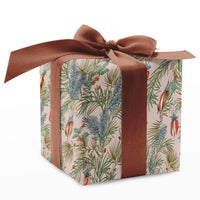 Square gift box wrapped in botanical holiday pattern paper with rust-colored ribbon bow. Illustrated by Lisel Ashlock.