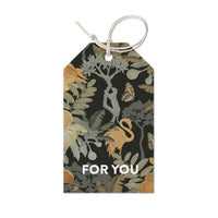 A dark botanical gift tag featuring illustrated flora, fauna, and "FOR YOU" text, illustrated by Lisel Ashlock.