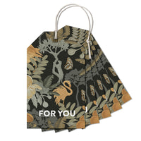 A fan-shaped stack of gift tags with botanical illustrations featuring butterflies, flowers, and foliage in earth tones, with "FOR YOU" text, attached to white cord. Illustrated by Lisel Ashlock.