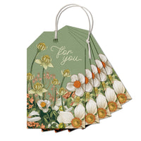 Stack of green gift tags featuring white anemone flowers and gold botanical illustrations with "for you" text. Illustrated by Lisel Ashlock.