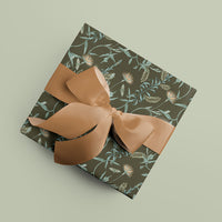 Wrapped gift with Lily Tree in Spruce patterned paper and tan ribbon bow on pale green background. Illustrated by Lisel Ashlock.